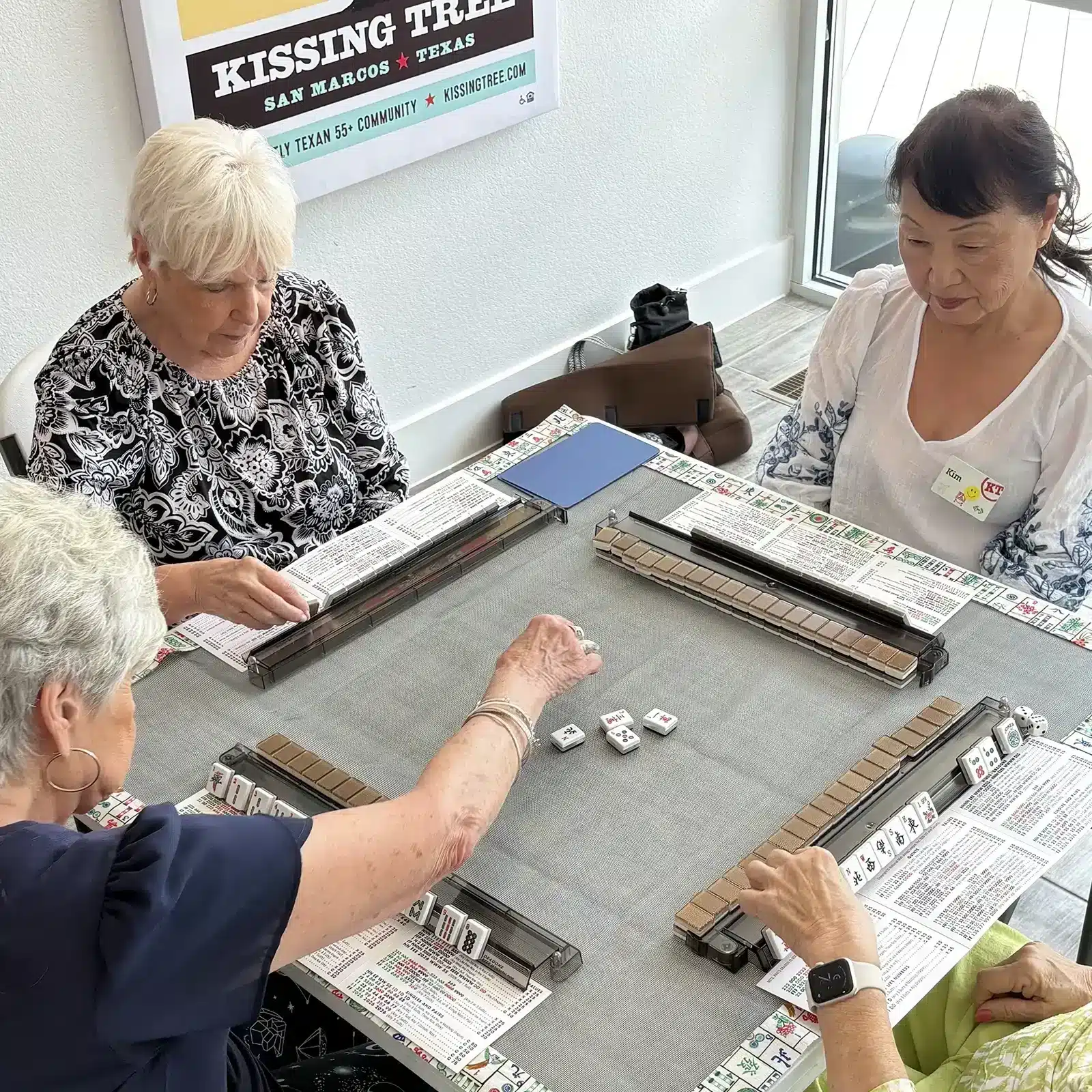 three women playing mahjong at kissing tree