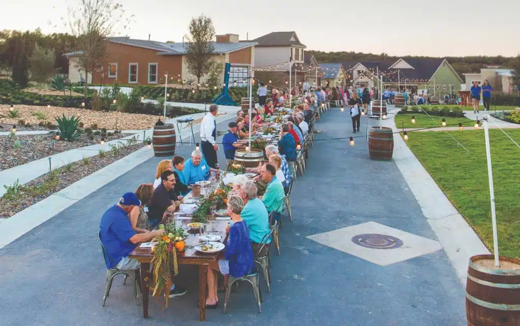 Residents gather for an outdoor community dinner at Kissing Tree, San Marcos, Texas