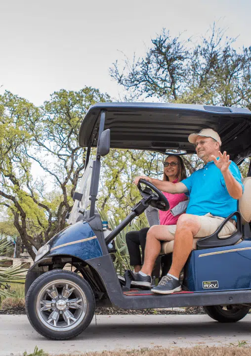 Man driving golf cart with his wife