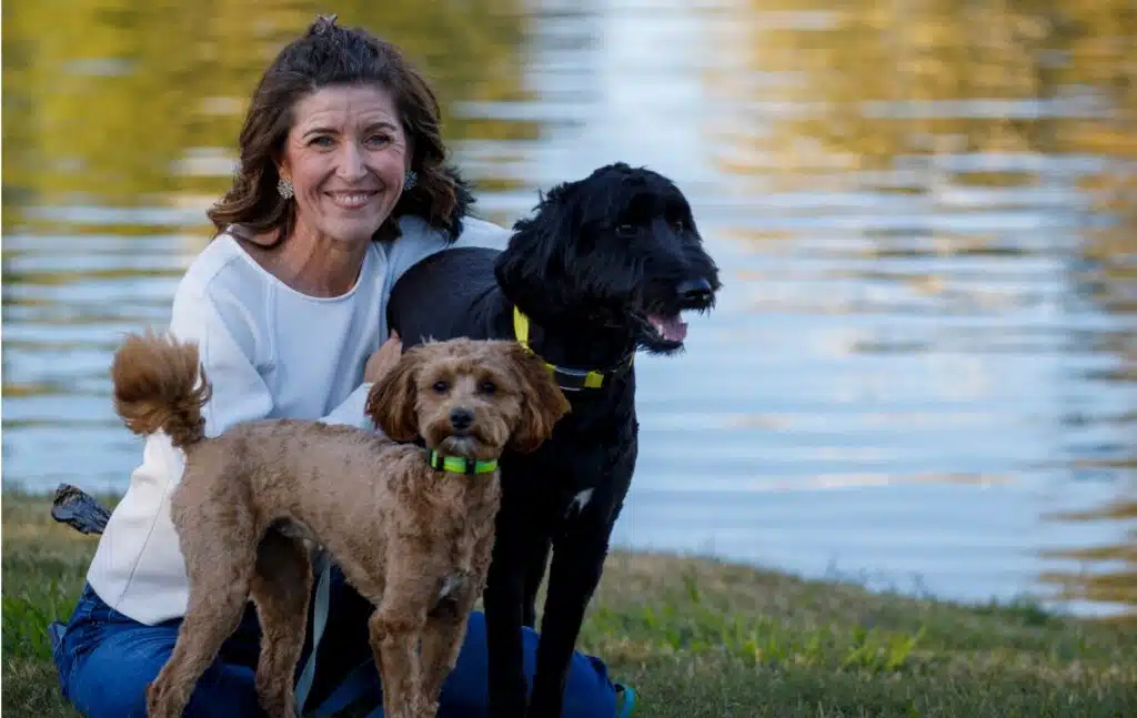 Woman outdoors with dogs by a lake