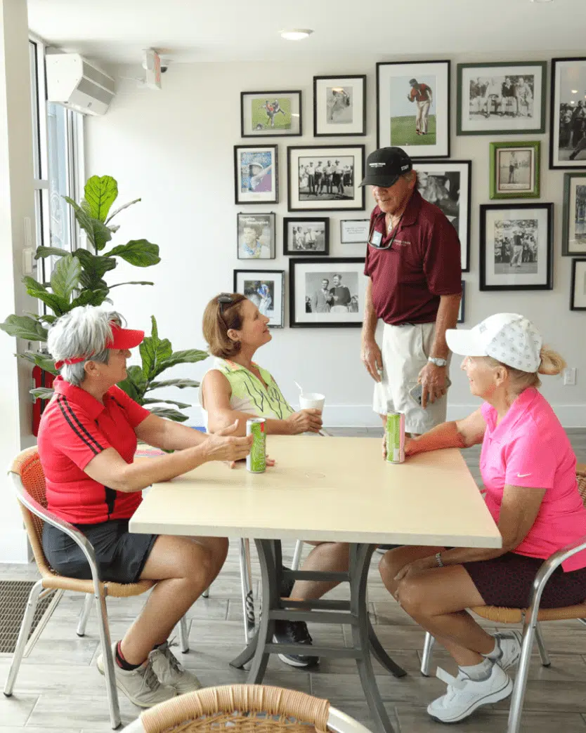 People inside of the Stump Cafe at the Kissing Tree Gold Course with a lot of golf images in the wall